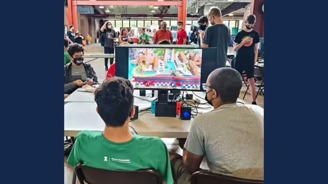two youth facing a video game screen and playing