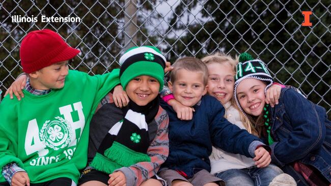group of children in 4-H gear hugging outside