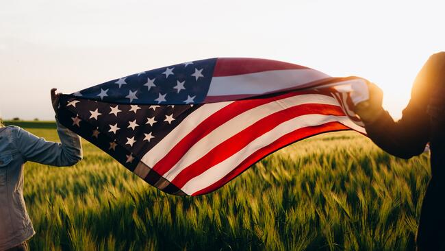 american flag flying over wheat field