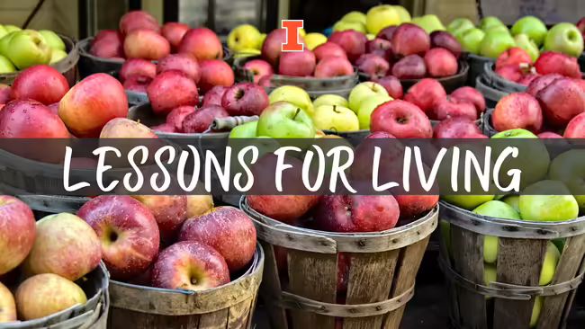 Bushels of different types of apples in old wooden baskets. Text in middles reads Lessons for Living