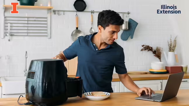 Man looking up air fryer recipes on a laptop