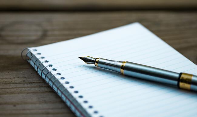 notebook and pen on a wooden table