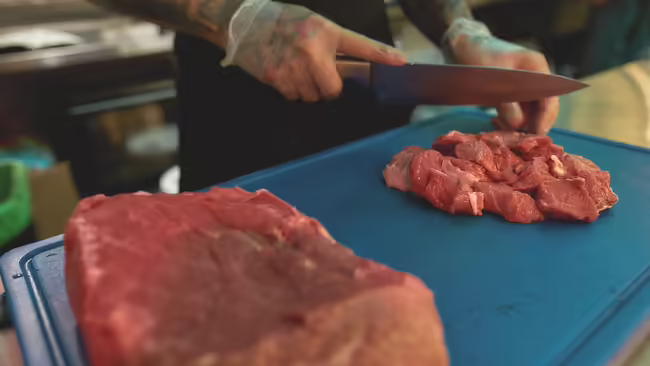food being cut on a blue cutting board