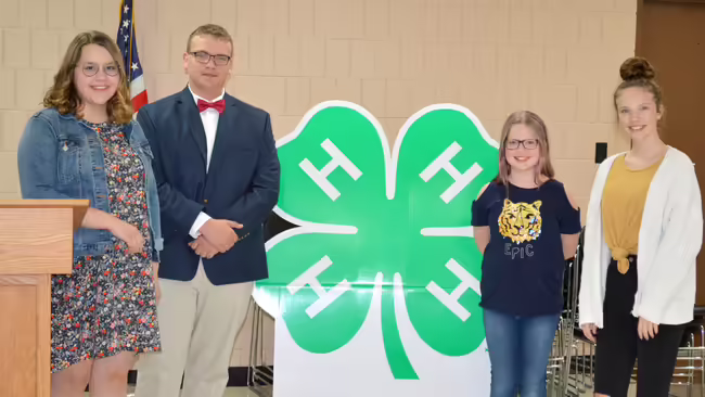 group of kids standing by a podium