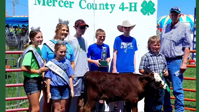 4-H members with a cow and trophies