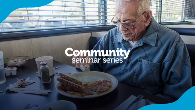 older adult eating at a diner/restaurant putting salt on his food