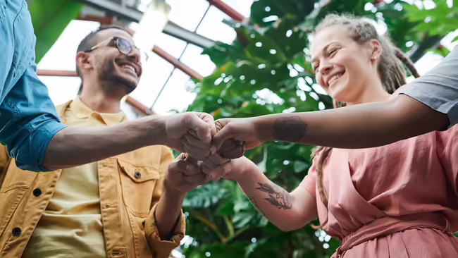 four adults fist bumping