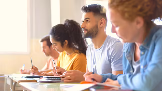Adult students taking notes in class