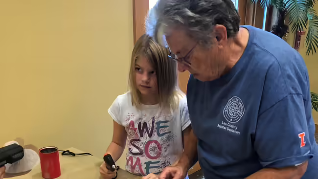 Master Gardener helping youth at gardening activity