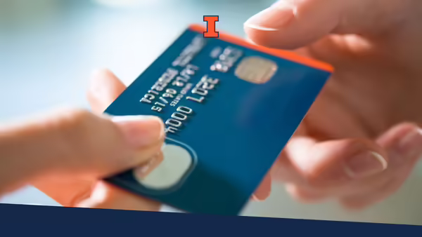 A hand passing a credit card to a store clerk.