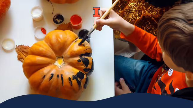 A child painting a pumpkin.