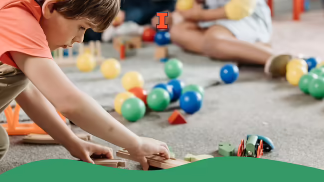 A child putting together a train set track.