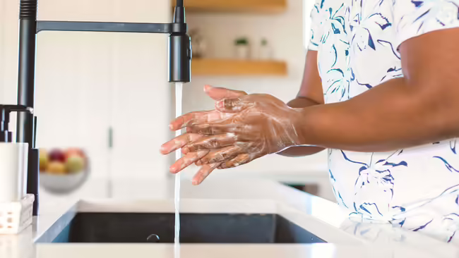 Man washing hands at kitchen sink
