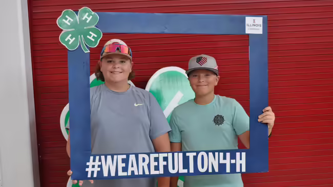 two 4-H boys holding a big frame
