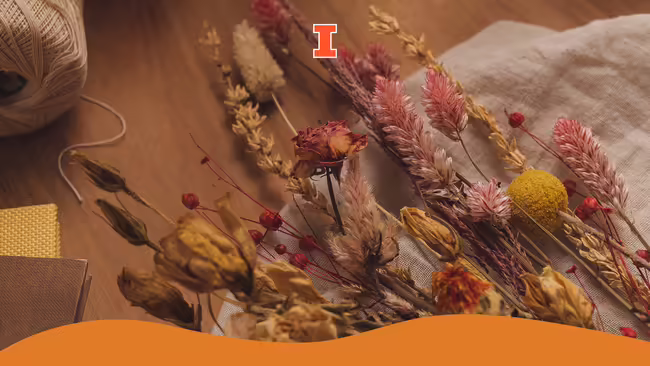A bouquet of fall flowers sitting on a wooden table.