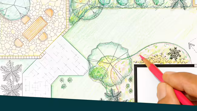 A person holding a colored pencil designing a landscape and garden.
