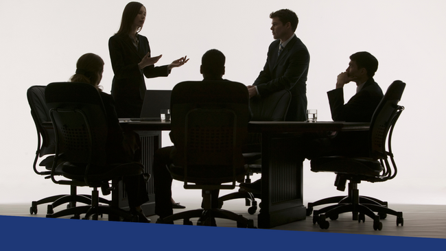 People sitting around a table conducting a meeting.