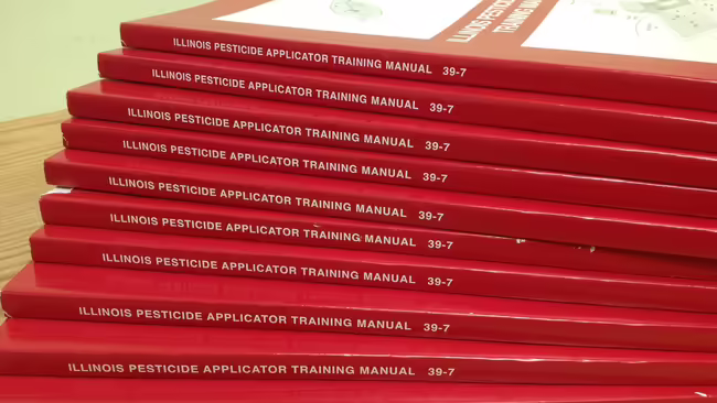 stack of pesticide applicator training books