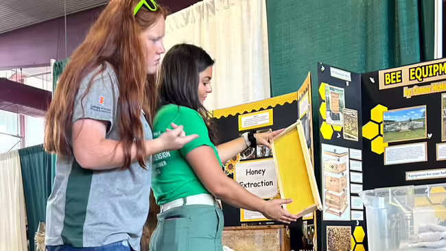 Two youth examine a project on display.