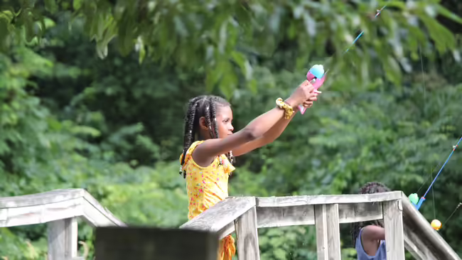 Girl fishes off a bridge.