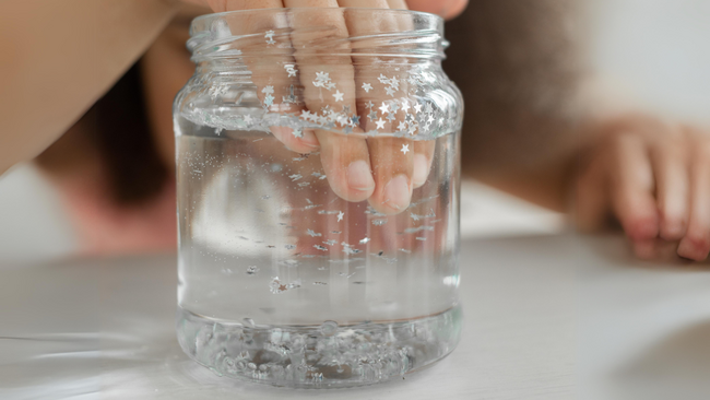 youth has there hand in a jar of water