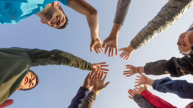 youth lean in to join hands.