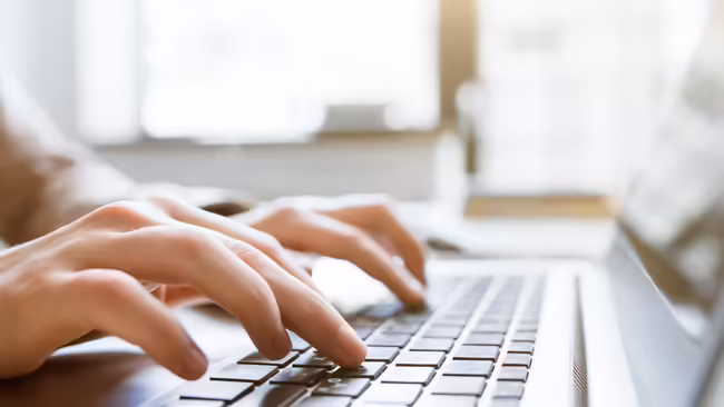 Hands typing on a keyboard.