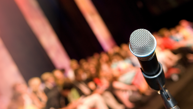 A microphone facing a crowd. 