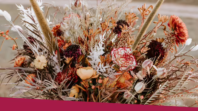 A variety of white, red, and orange flowers made into a floral bouquet.