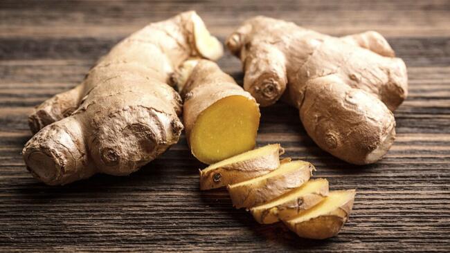 full ginger root and slices of ginger