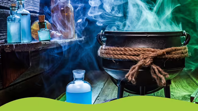 Large black cauldron with smoke rising out of it and science beakers filled with blue liquid.