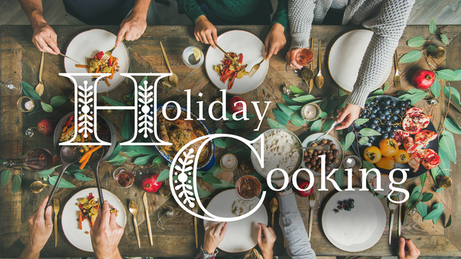 six sets of hands enjoying a meal around a festive table