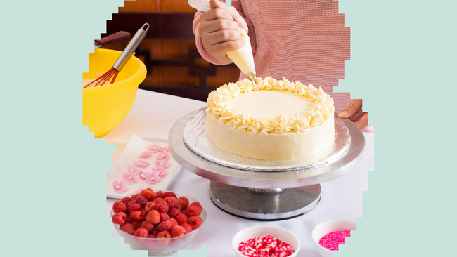 child's hand decorating a cake