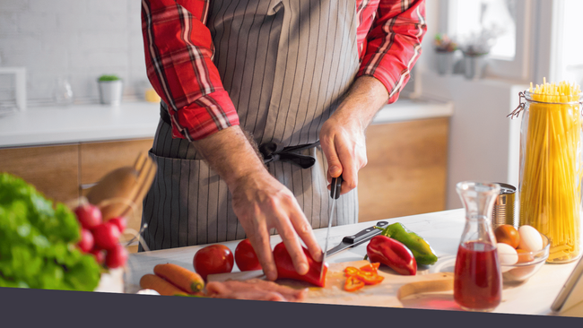 A person cutting vegetables on a cutting board kitchen.