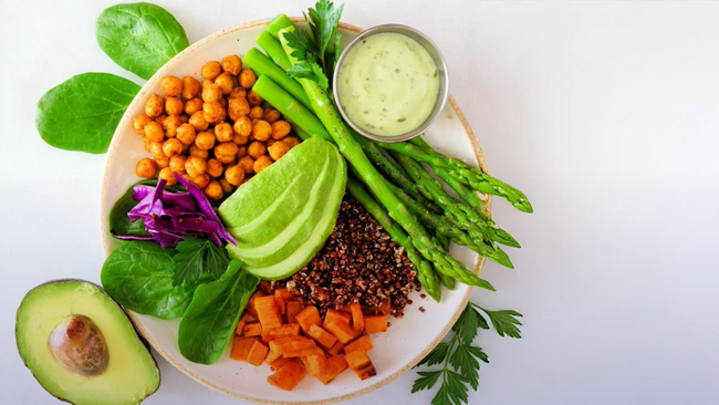 A plant-based diet sitting on a white plate on a white background with a purple gradient over the image.