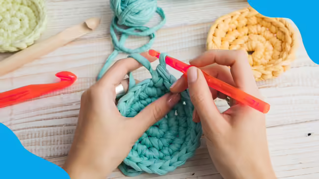 Hands crocheting with blue corner graphics.