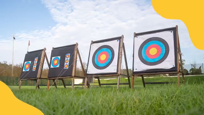 Archery targets sitting on grass with yellow corner graphics.