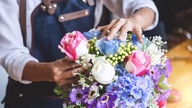 Person in apron arranging flowers