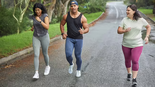 Three adults walking on road