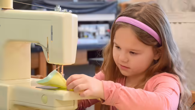 a little girl sewing