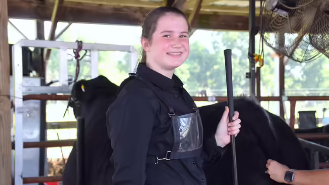 girl with a cow in the background