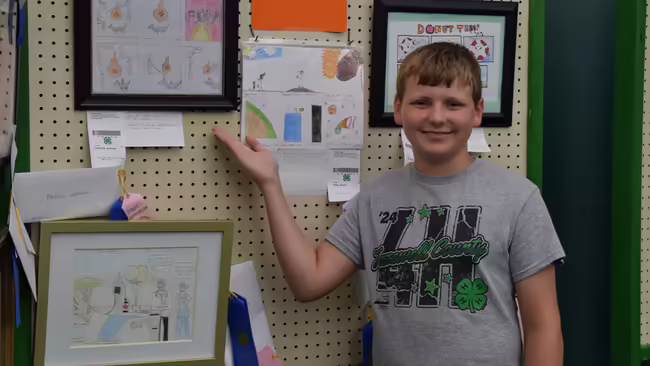 a 4-H member displaying his art work