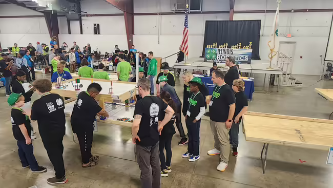 Robotics competitors gather around a table. 