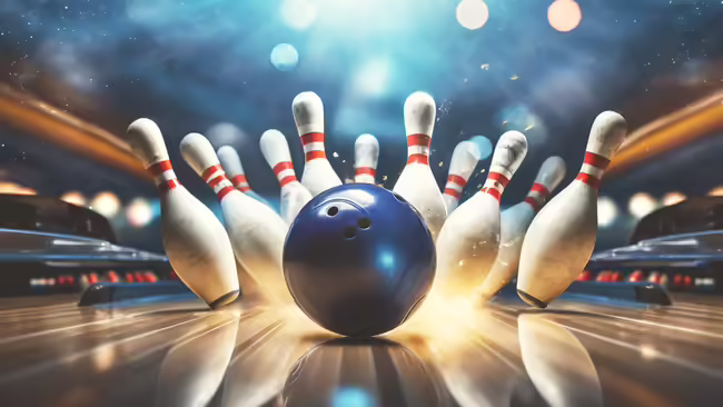 Blue bowling ball striking white pins with red stripes on a shiny wooden lane, creating a dynamic action scene at a bowling alley.