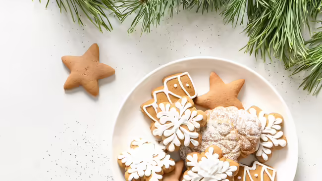 holiday cookies on a plate beside holiday greenery