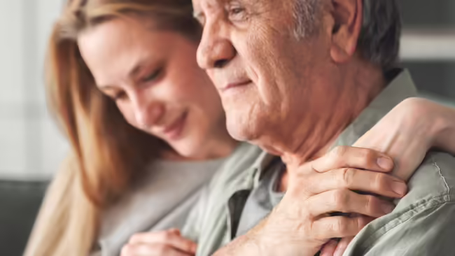 woman with arms around man's shoulder