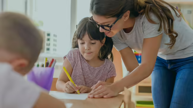 A teen girl tutoring a young girl