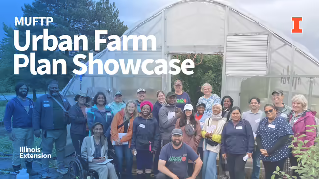 Group photo of adults in front of a hoop house outdoors. 