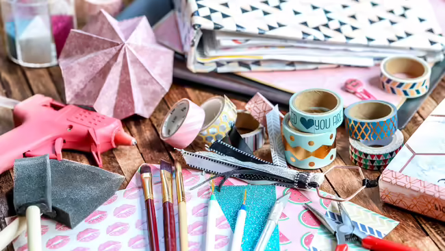 Scrapbooking supplies such as a scrapbook, paint brushes, patterned paper, etc.