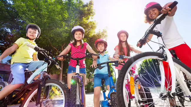 multiple youth riding bicycles outside